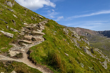 A Rocky Hiking Path Leading Up a Steep Green Hillside © GaborSzanto