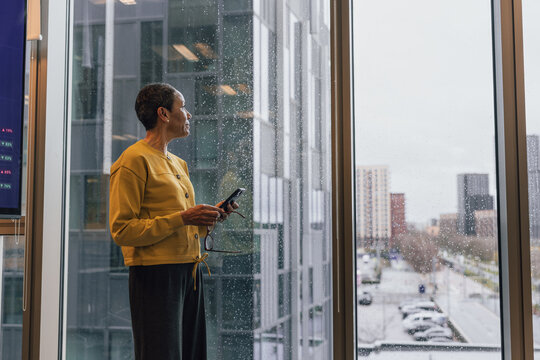 Contemplative Mature woman Observing city on a grey day