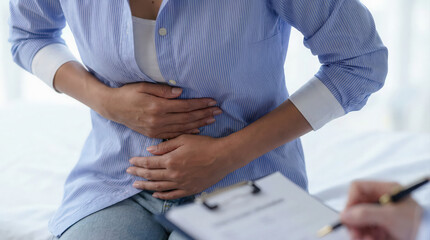 Obraz premium Woman suffering from abdominal pain during medical consultation