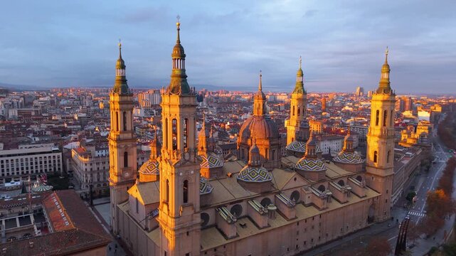 Aerial View Capturing Sunset Glow Illuminating Cathedral Domes And Tranquil River Reflections. Zaragoza. Spain 