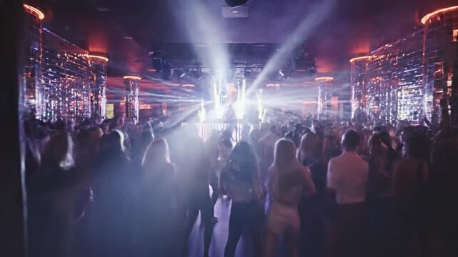 A dimly lit interior with a man in a suit on the right, looking out at a crowded party scene with flashing lights and smoke