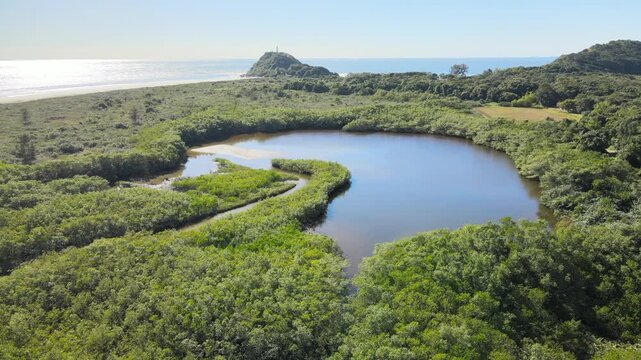 Voo de drone sobre Ilha do Mel do lado de Bras&iacute;lia no Litoral do Paran&aacute; sobre canal fluvial no mangue na mata atl&acirc;ntica em Paranagu&aacute; com farol das conchas