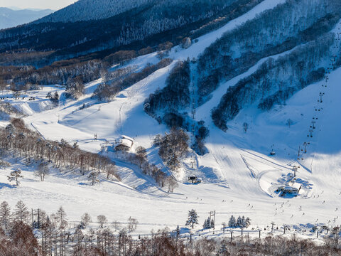 Winter landscape showing ski lifts and runs at Madarao Mountain Resort, Japan