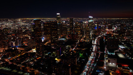 Fototapeta premium Los Angeles night skyline with city lights. Night aerial view of Los Angeles downtown illuminated by city lights.