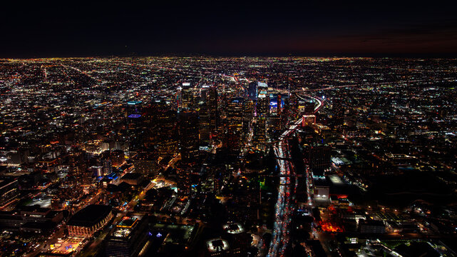 Downtown Los Angeles skyline at night. Glittering city lights and traffic streams surround the DTLA towers after dark.