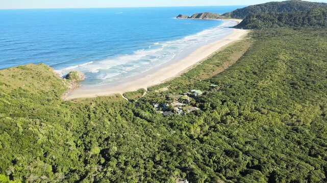 Voo sobre Ilha do Mel no litoral do Paran&aacute; em Parangu&aacute; com mar e c&eacute;u azul na praia grande na mata atl&acirc;ntica