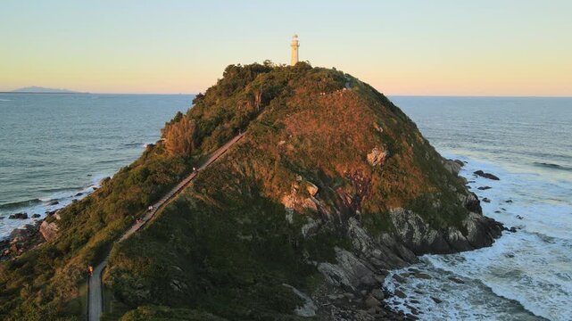 Voo sobre Farol da Conchas na Ilha do Mel no litoral do Paran&aacute; em Paranagu&aacute; ao entardecer p&ocirc;r-do-sol durante da golden hour com c&eacute;u limpo