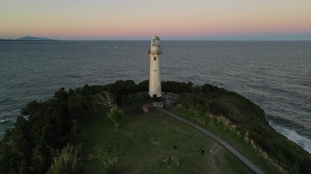 Voo sobre Farol da Conchas na Ilha do Mel no litoral do Paran&aacute; em Paranagu&aacute; ao entardecer p&ocirc;r-do-sol durante da golden hour com c&eacute;u limpo