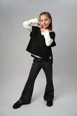 Portrait of a Happy Young Schoolgirl in Stylish Uniform. A full-length studio portrait of a smiling...