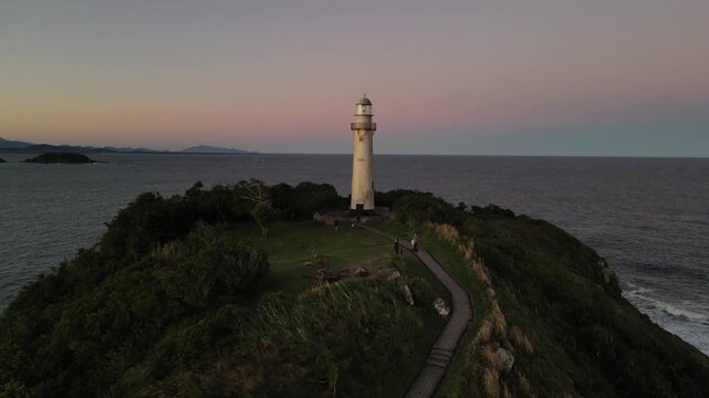 Voo sobre Farol da Conchas na Ilha do Mel no litoral do Paran&aacute; em Paranagu&aacute; ao entardecer p&ocirc;r-do-sol durante da golden hour com c&eacute;u limpo