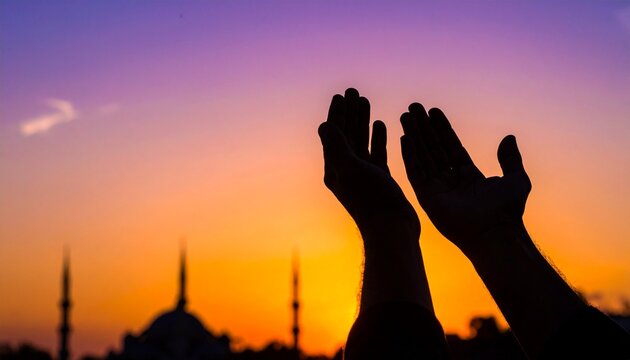Silhouette de mains musulmanes en pri&egrave;re (Dua) avec une mosqu&eacute;e en arri&egrave;re-plan au coucher du soleil, concept spirituel du Ramadan