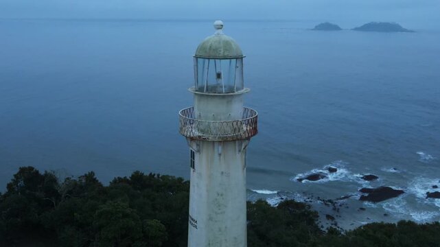 Voo sobre Farol da Conchas na Ilha do Mel no litoral do Paran&aacute; em Paranagu&aacute; ao amanhecer durante da Blue hour ao nascer do sol com neblina e clima dram&aacute;tico