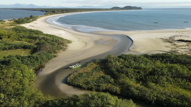 Voo de drone sobre Ilha do Mel do lado de Bras&iacute;lia no Litoral do Paran&aacute; sobre canal fluvial no mangue na Praia do Istmo com mar oceano atl&acirc;ntico azul em Paranagu&aacute;
