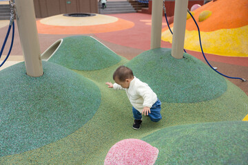 Baby playing joyfully at outdoor kid park