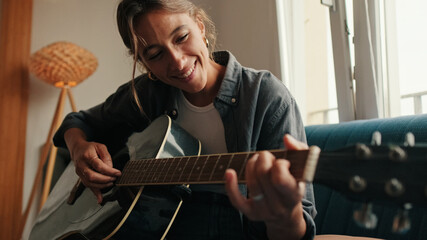 Woman Playing Acoustic Guitar At Home, Smiling