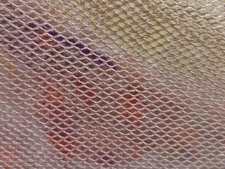Macro Texture of Beige Synthetic Mesh Fabric - Close-up of Fine Hexagonal Netting Material with Blurred Abstract Background