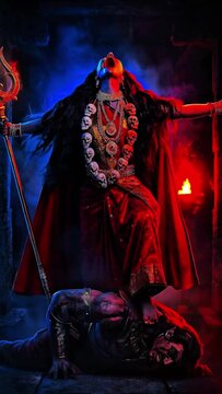 Goddess Kali wearing a skull necklace and holding a spear on fire.