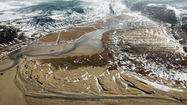 Aerial view of a stark landscape where the river carves through the golden earth, a testament to nature's enduring power, Selfoss, Iceland.