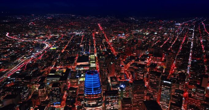 Vast night panorama of San Francisco, California, USA at night. Flying above the neon top of Salesforce Tower.