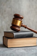 Obraz premium Gavel resting on stacked law books.