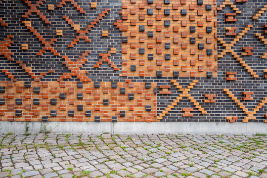 Abstract brick wall pattern with geometric texture showing urban architecture design in masonry above pavement background for modern construction