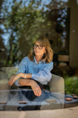Obraz premium Portrait of a blond haired woman photorgraphed through a window