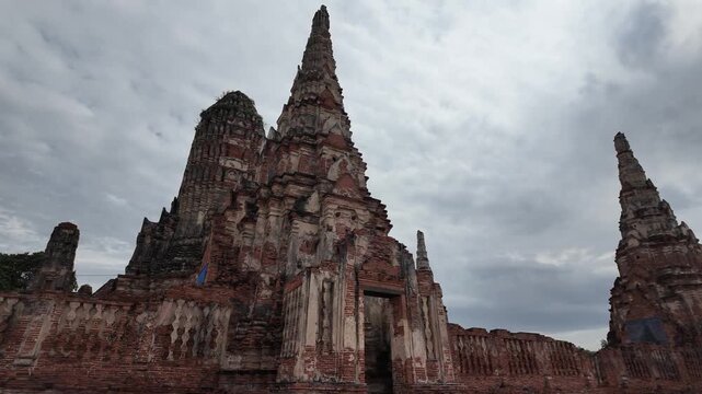 ancient wat chaiwatthanaram temple complex with tiered prang spires under cloudy sky, ayutthaya, thailand
