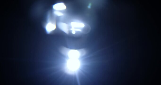 Artistic abstract background showcasing captivating light reflections and diffractions against a dark backdrop. Kaleidoscope effect, refraction of light through a prism. Slow motion.