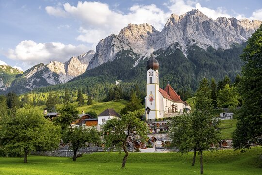 Cemetery and church of St. John the Baptist, mountain peak of the Wetterstein Mountains at the back, Grainau, Bavaria, Germany