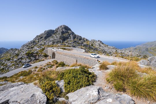 Car at the mountain pass with switchbacks to Sa Colobra, Nus de Sa Corbata road loop, Serra de Tramuntana, Majorca, Balearic Islands, Spain