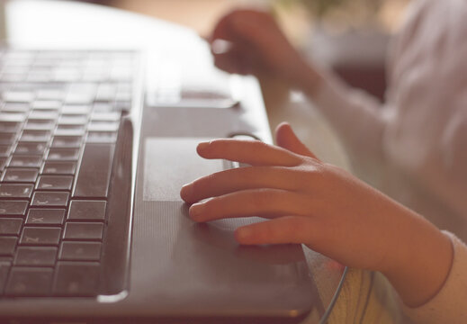 Close-up side view of a young Girl using a laptop computer