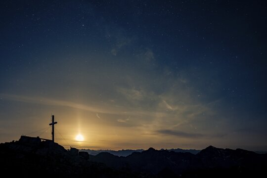 Summit cross of the Namloser Wetterspitze at full moon and Lechtaler Alps, Namlos, Reutte, Lechtal, Au&szlig;erfern, Tyrol, Austria
