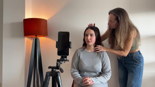 Amiga ajustando el cabello de la influencer en el set de grabaci&oacute;n