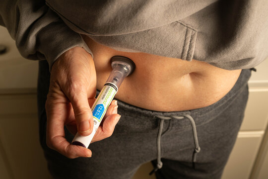 Limestone, TN, USA-January 28, 2026:  Woman using an injector pen to administer Zepbound into abdomen.