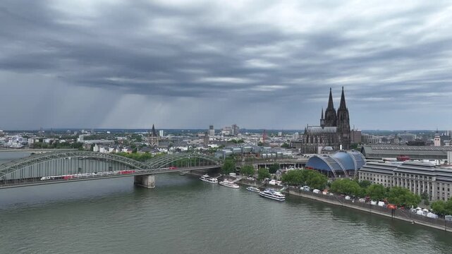 Cologne City Cathedral and Central Train Station, Hbf. Germany, Drone. Hohenzollern Bridge. Stormy Sky