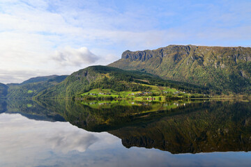 Mountain Reflections on Granvinsvatnet Lake, Norway. Scenic Norwegian lake with clear reflections of forested mountains and rural settlements in Vestland county.