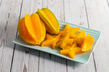 Obraz premium Star fruit is a tropical, juicy fruit with crisp texture, sweet tart flavor, and distinctive star shaped slices when cut. 