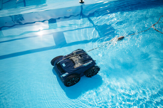 Robotic pool cleaner working underwater to keep swimming pool clean.