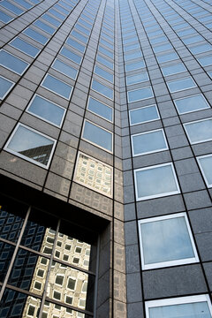 Modern corporate office architecture in urban Paris shown as glass skyscraper facade reflection with repeating vertical blocks monolith with clean lines