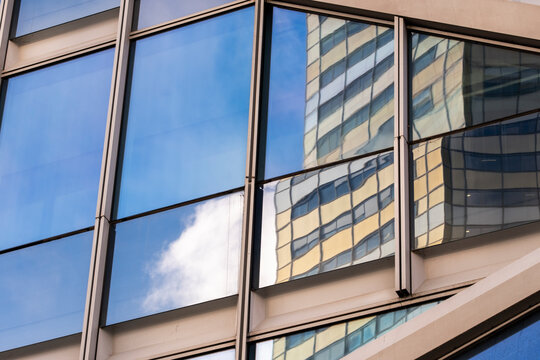 Modern corporate office architecture in urban Paris shown in glass skyscraper facade reflection with minimal abstract window panes and frames