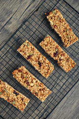 Gluten-free oat granola bars with nuts and berries on a black cooling rack
