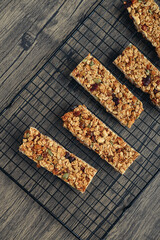 Gluten-free oat granola bars with nuts and berries on a black cooling rack