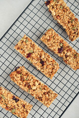 Gluten-free oat granola bars with nuts and berries on a black cooling rack