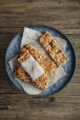 Gluten-free oat granola bars with nuts and berries on round vintage metal tray