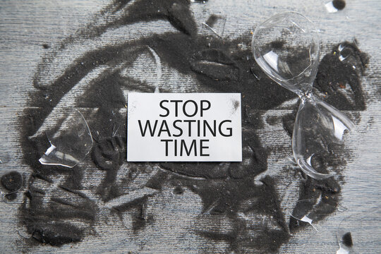 Broken hourglass with a Stop Wasting Time message.