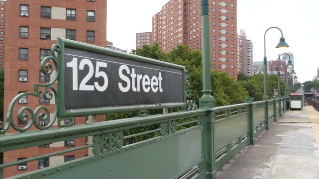 New York City Upper Manhattan subway outdoor station platform, 125 street sign, elevated metro in Harlem, United States railway. Residential district public metropolitan transport. Apartment houses.