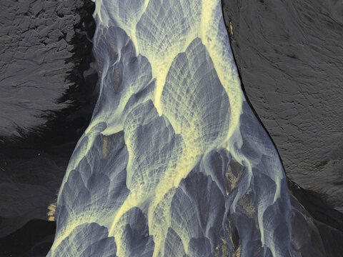 Aerial view of glacial rivers create intricate patterns as they weave through the stark, volcanic landscape, Tjarnabyggd, Iceland.
