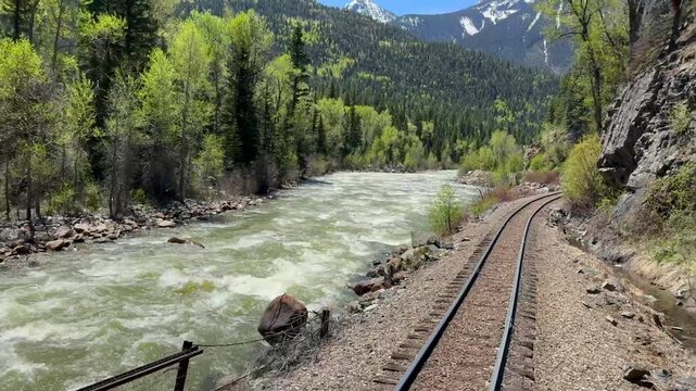 Scenic view of the railway track alongside the Animas River from the back of a train on the Durango and Silverton narrow gauge railway
