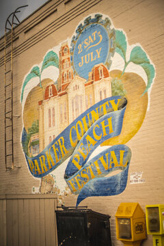 Parker County Peach Festival Mural With Peaches and Courthouse Building Painted on Side of Wall in Weatherford, Texas