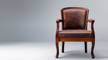 Fototapeta premium Classic wooden armchair with brown leather upholstery on gray background 